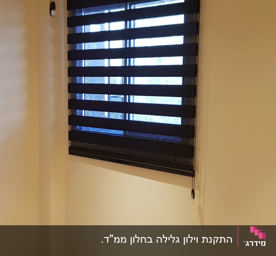 וילון רצועות אופקי שחור על חלון
